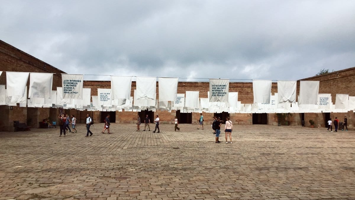 Interior courtyard of Castell de Montjuïc with white flags showing messages of peace