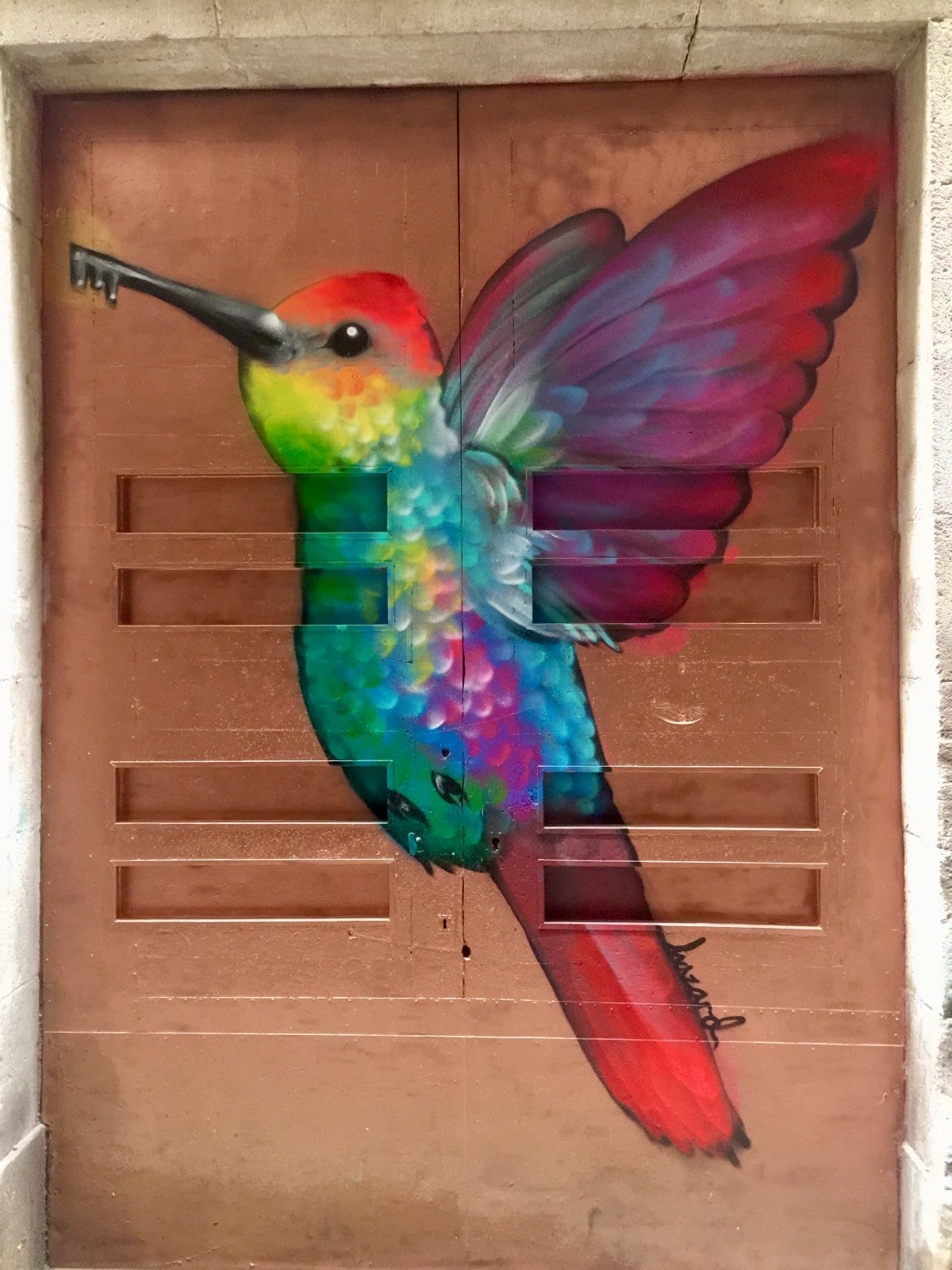 Street art mural of a bird painted on a shop shutter